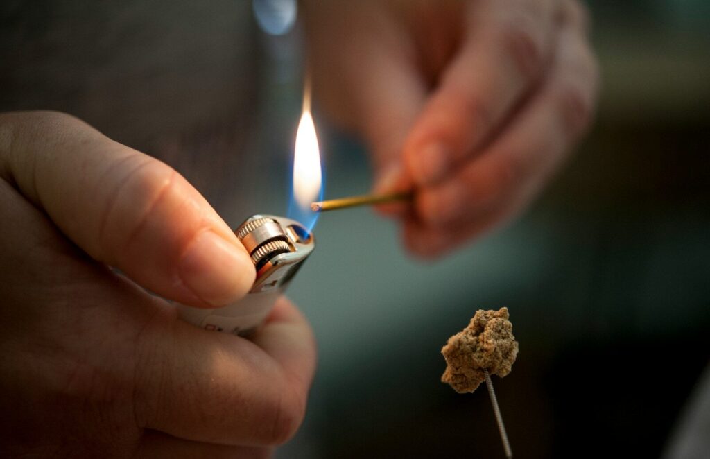 Photo by Katherine Hanlon person holding lighted lighter with fire